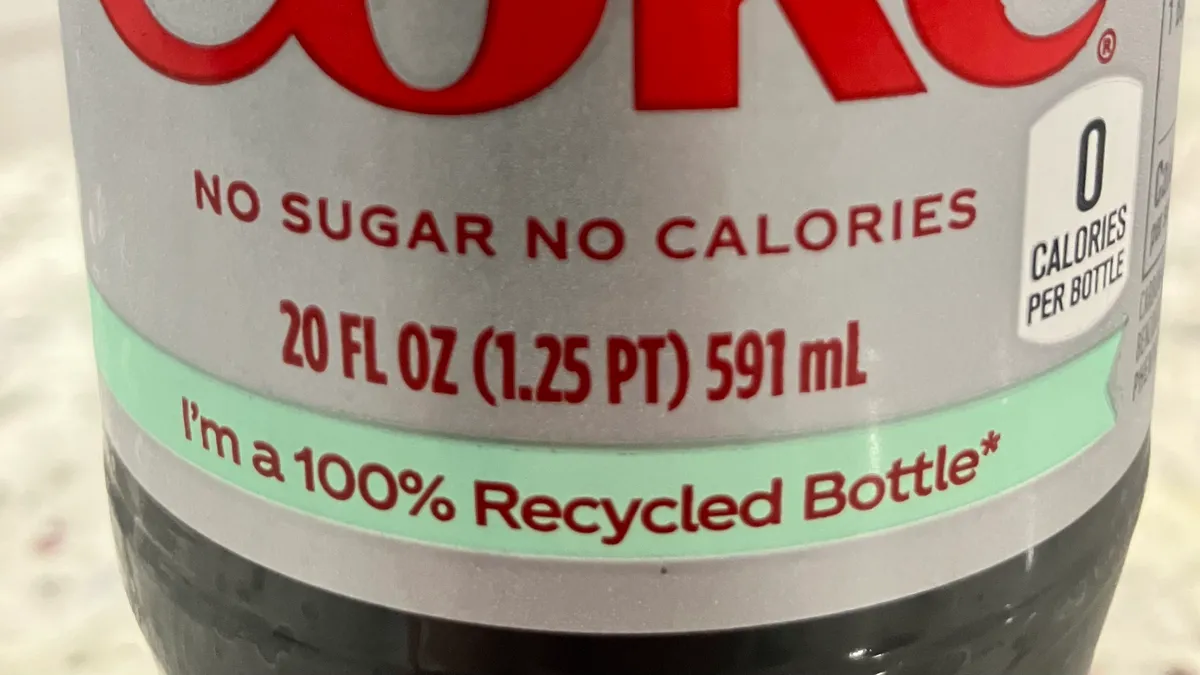 Close-up of a wrap label on a Diet Coke beverage bottle that says "I'm a 100% Recycled Bottle"