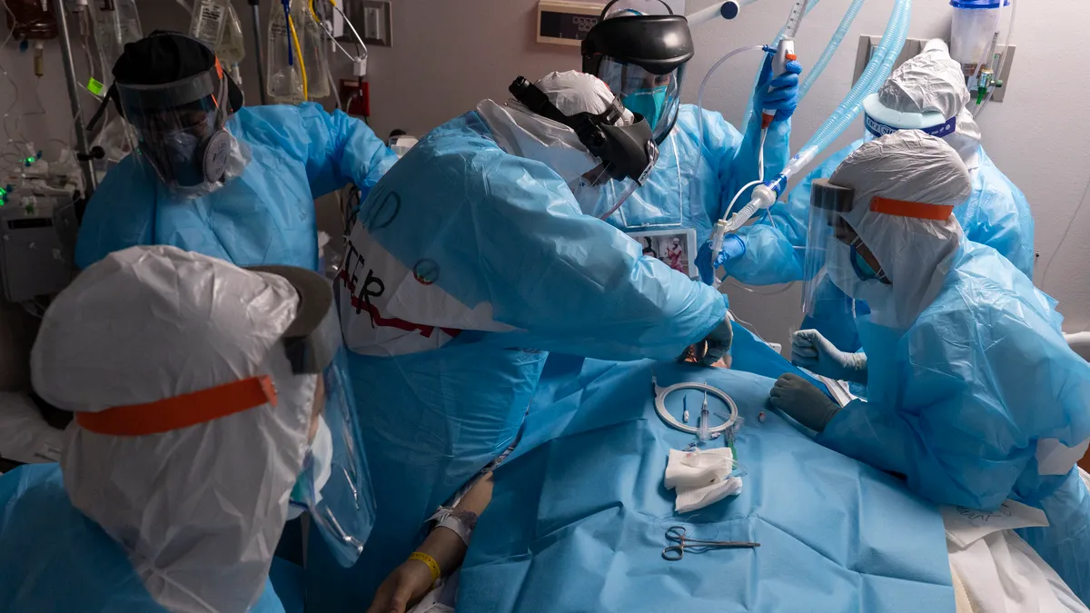 ) Dr. Joseph Varon, center, and other medical staff members perform tracheostomy procedure on a patient in the COVID-19 intensive care unit (ICU) at the United Memorial Medical Center on December 14,