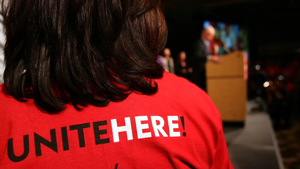 A hotel worker wears a Unite Here T-shirt.