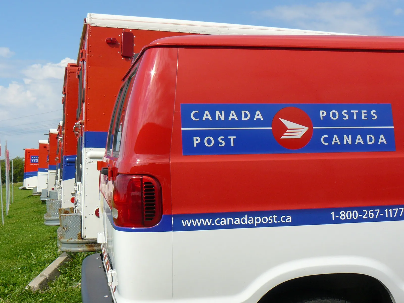 Canada Post vehicles lined up next to each other.