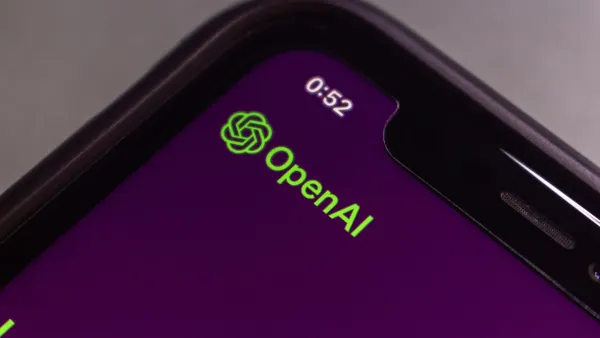 Extreme close-up of a smartphone screen showing a purple background with the OpenAI logo and the time “0:52” in the corner.
