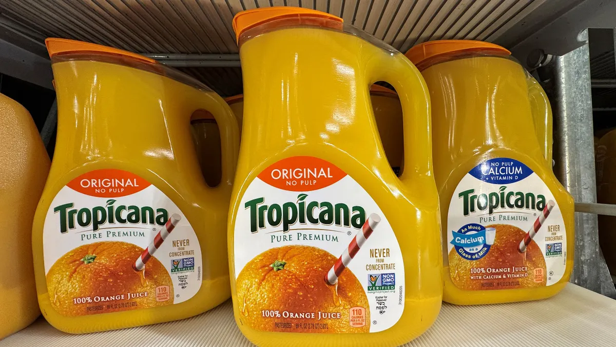 Gallon jugs of Tropicana orange juice on a store shelf.