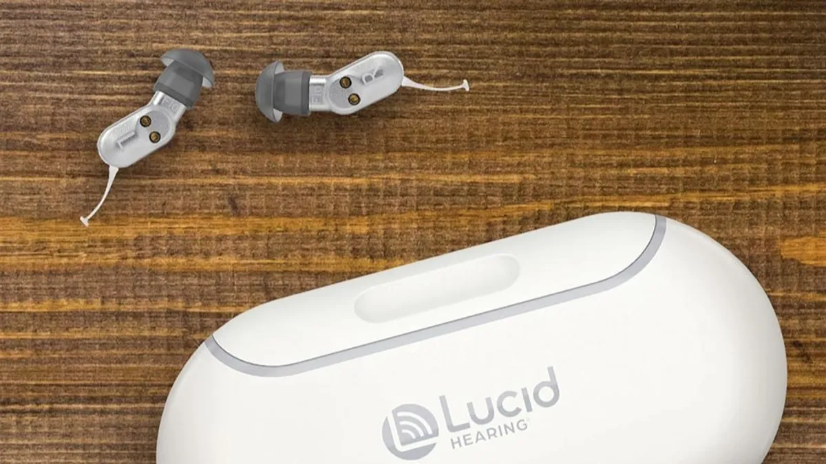 A pair of Lucid hearing aids shown with their container against a woven mat.