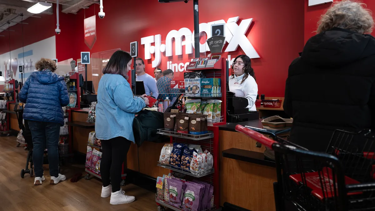 Customers make purchases at a T. J. Maxx store.