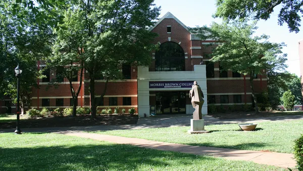 Brick building with sculpture in court yard and banner reading "Morris Brown College."