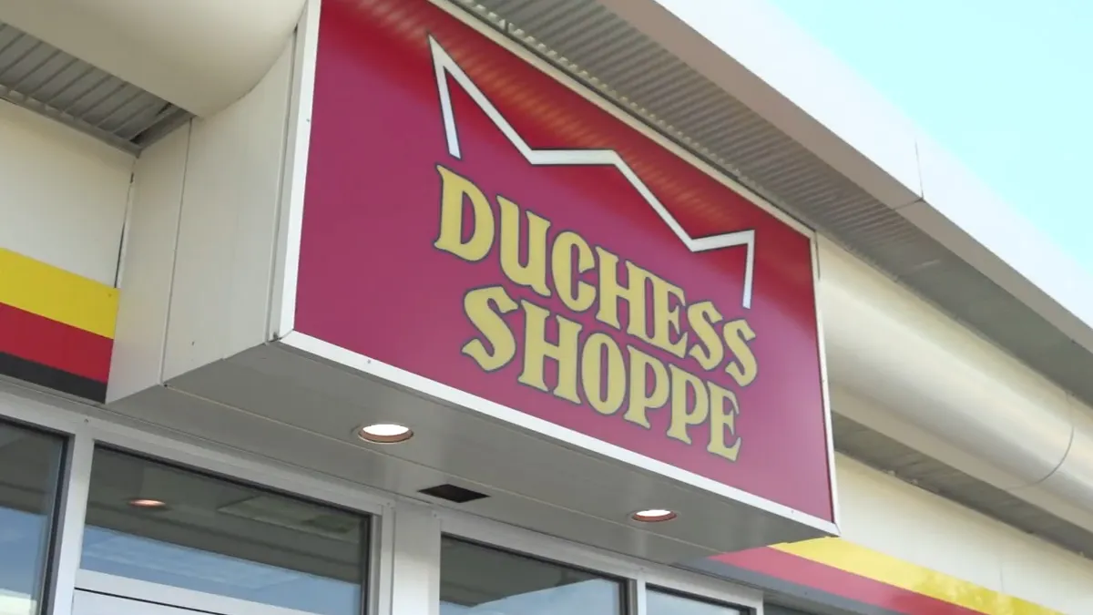 A photo of a red and white sign on a building. The sign reads Dutchess Shoppe.