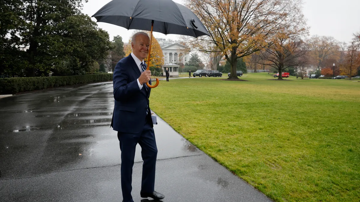 U.S. President Joe Biden uses an umbrella to keep out of the rain