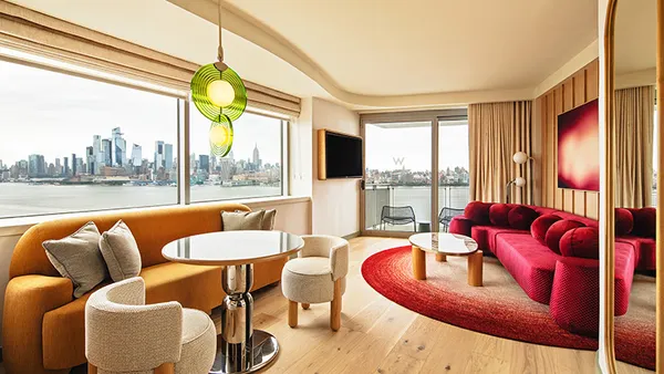 The inside of a guest room at W Hoboken in New Jersey overlooking New York City.