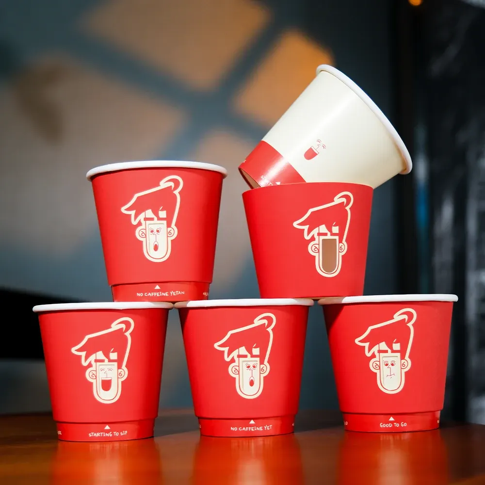 A stack of red paper cups with various images visible through cutouts on the outer layer.
