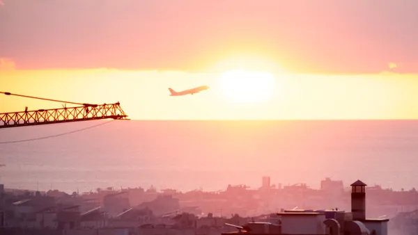 A plane taking off set against a sky with smoke.
