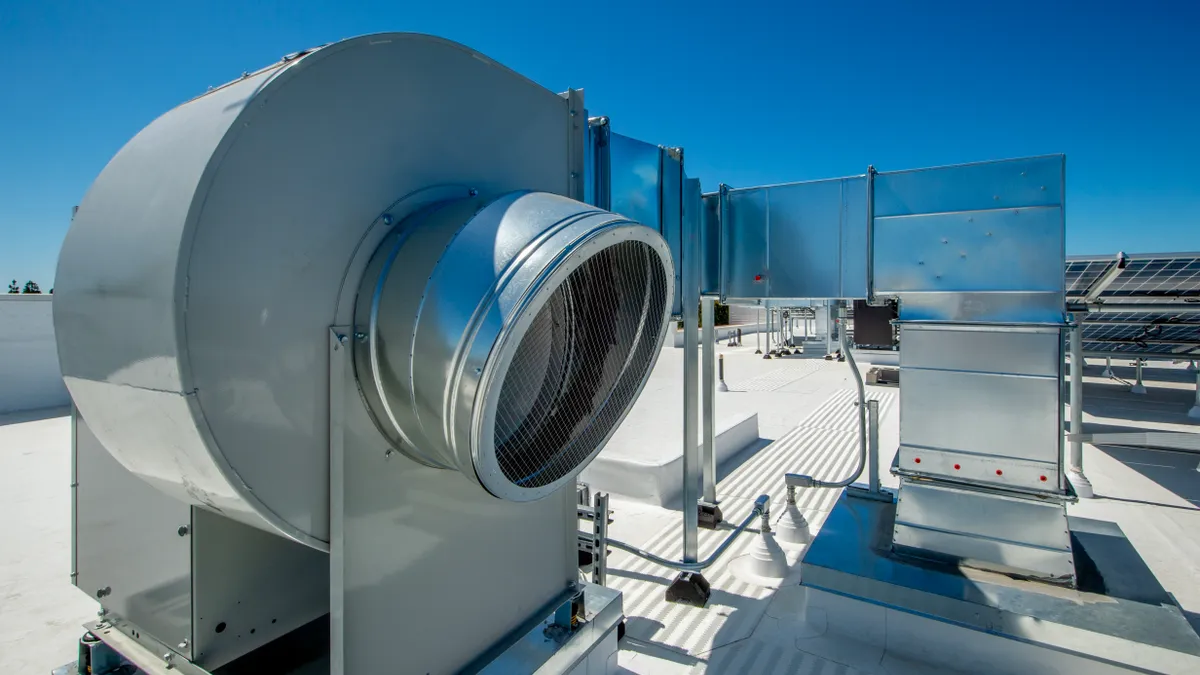 A view of fans and ducting for ventilation in a rooftop HVAC system.