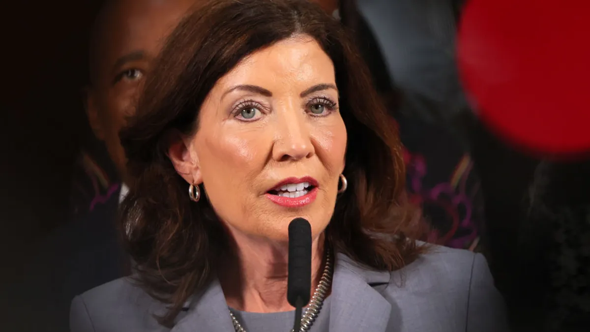 Headshot of a woman speaking into a microphone.