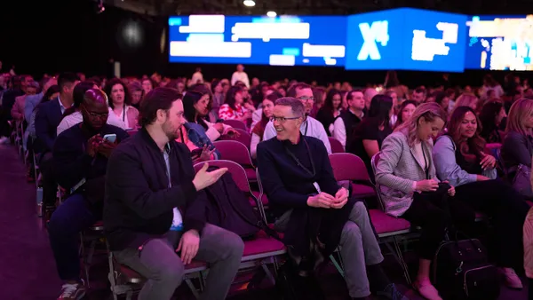 Attendees sitting in chairs at a conference.