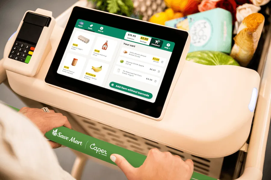 Close-up of someone using a smart cart for grocery shopping.