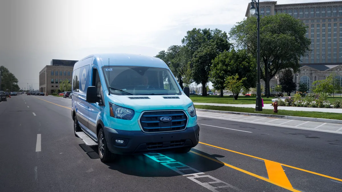 A blue Ford shuttle drives over a wireless charging roadway