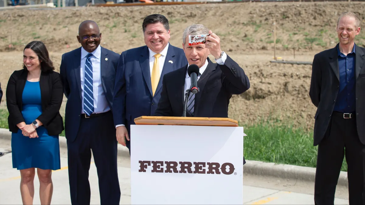 Gov. J.B. Pritzker holds up a Kinder Bueno bar at the announcement of Ferrero's second expansion in Bloomington, Illinois.