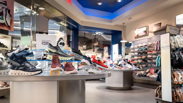 Shoes sit on display tables and shelves in a store
