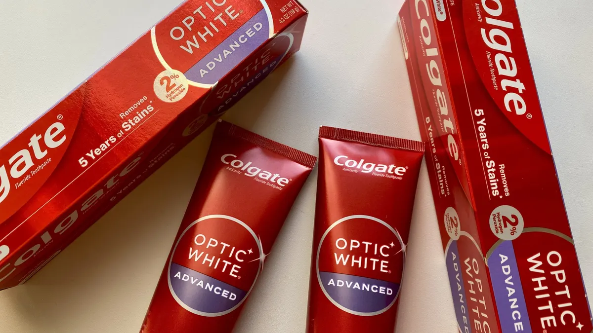 Two tubes of tooth pastes with packaging on white table