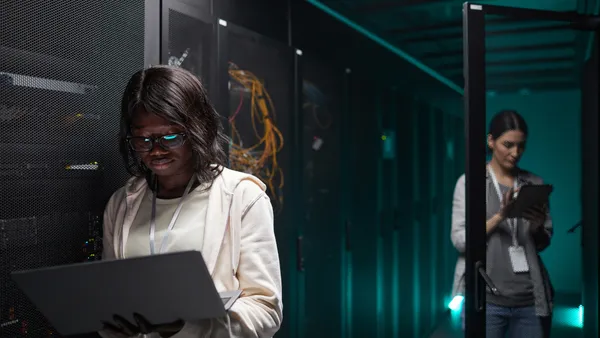 woman using laptop in server room