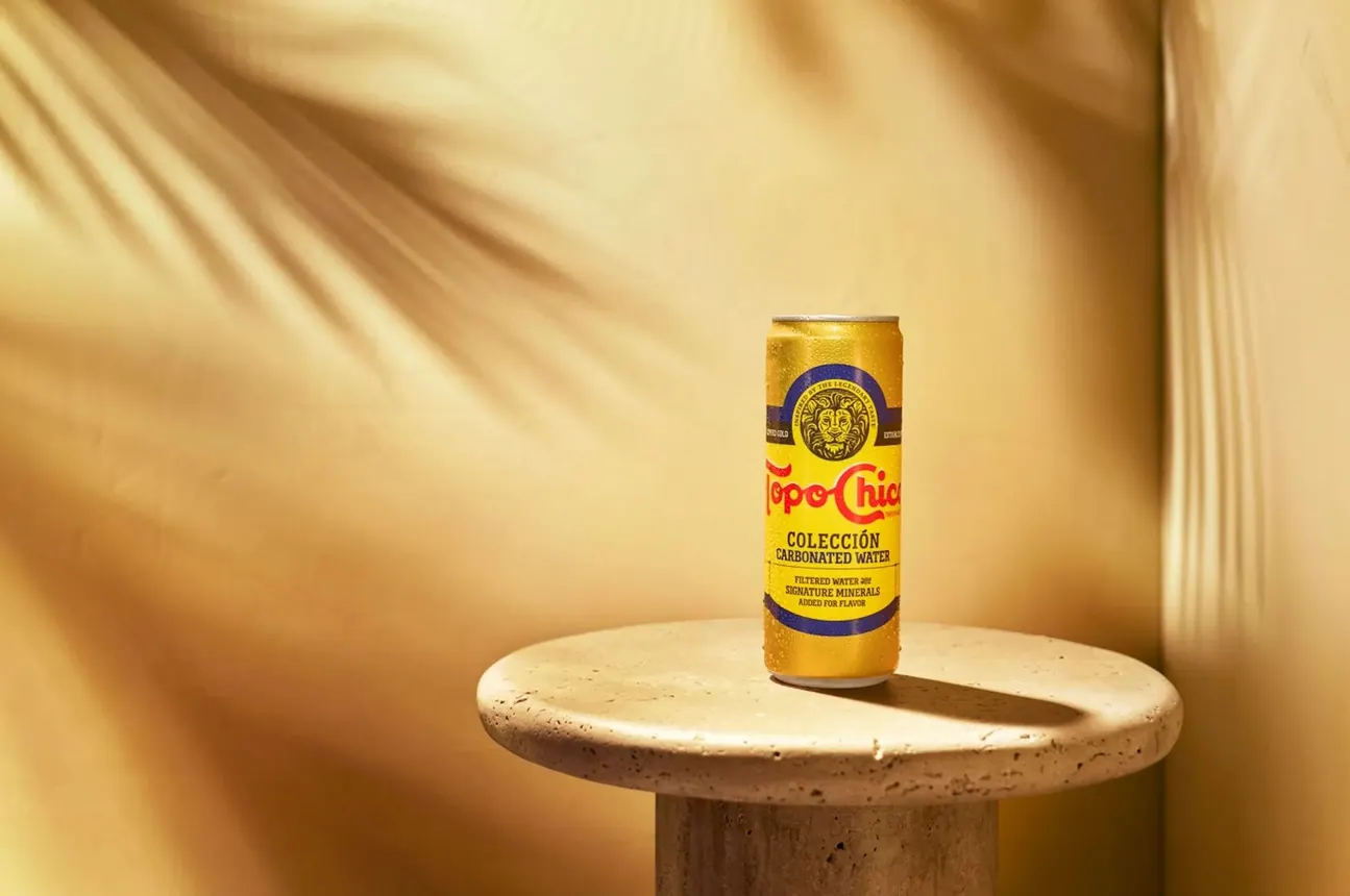 A can of Topo Chico Coleccion sits alone on a table.