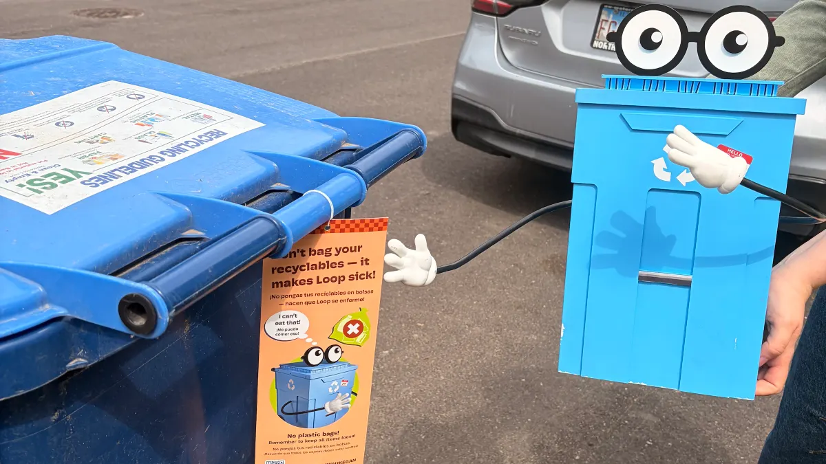 Loop, a recycling cart mascot, is displayed on the street