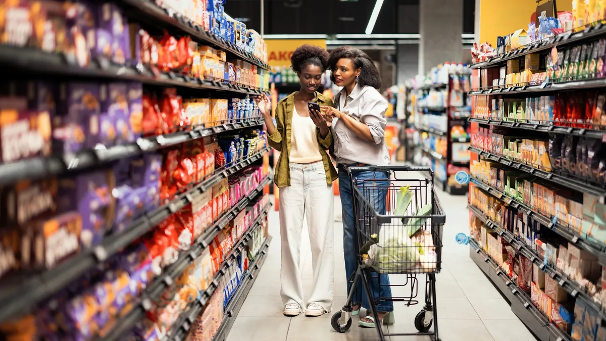 Two People Shopping Together In A Bright Grocery Store Aisle