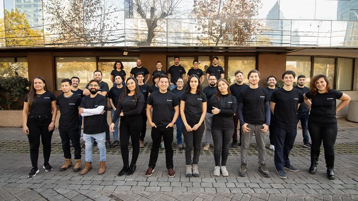 A group of Protera Biosciences employees in black shirts stand in front of a building.
