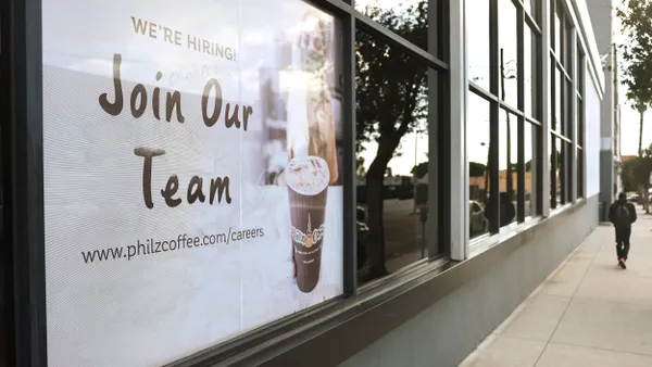 A 'Join Our Team' sign is posted outside a coffee shop.