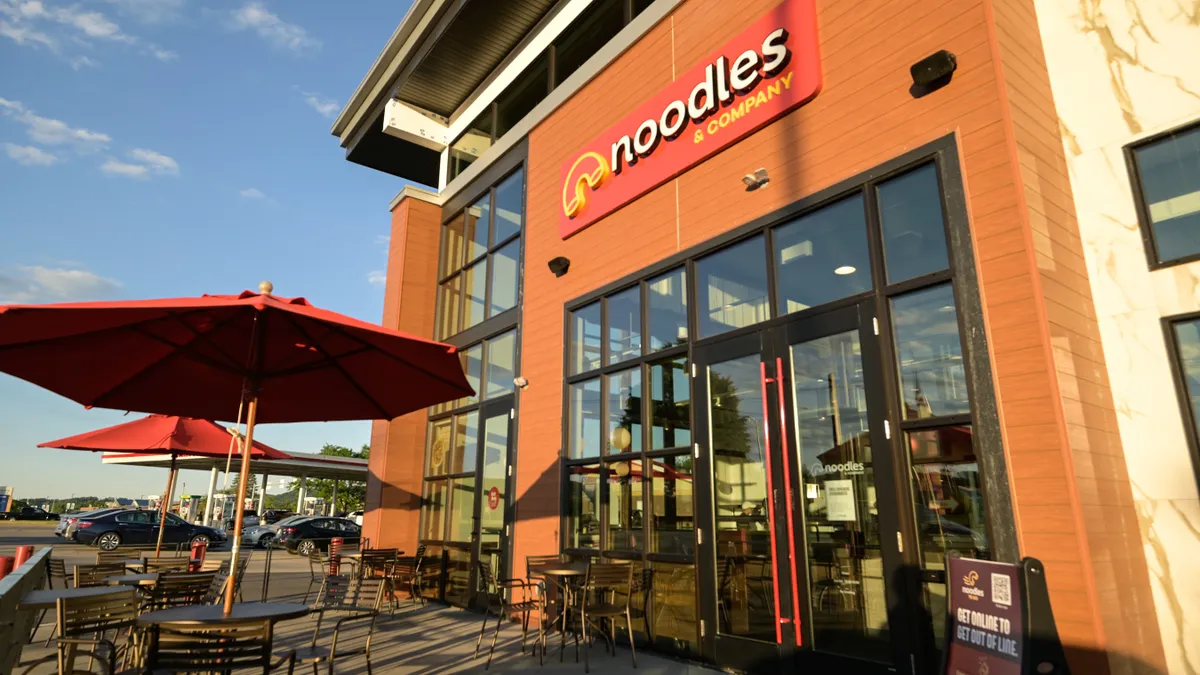 An image of a Noodles & Company restaurant with outdoor seating