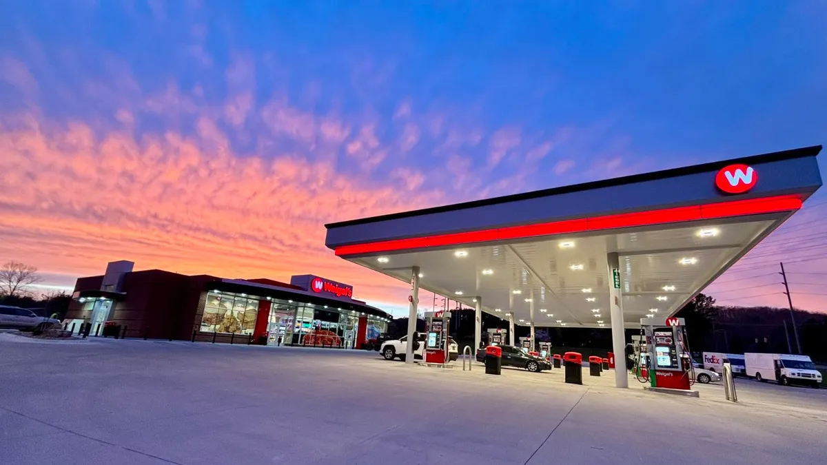 A photo of the forecourt and exterior of a convenience store. A red and white sign on the store says Weigel's.