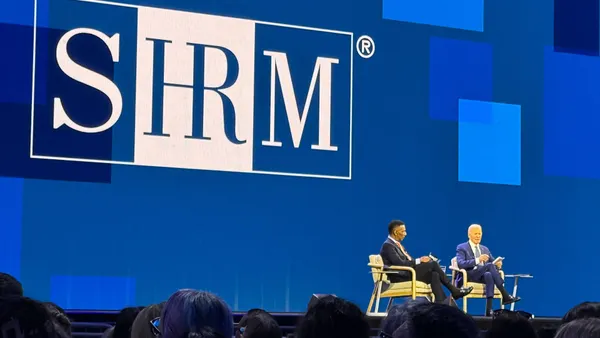 Former president Joe Biden speaks on stage at a conference.