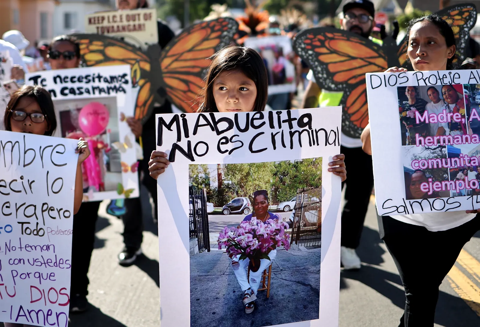 Demonstrators carry signs in a protest over immigration enforcement activities in Los Angeles.