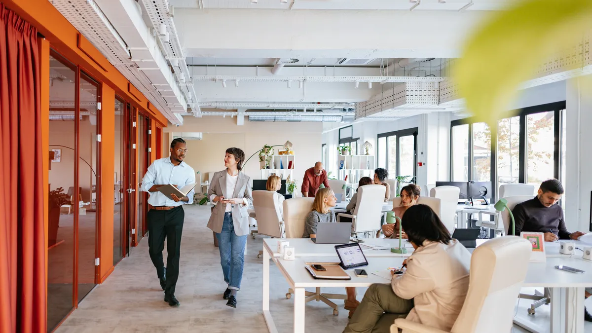 Group of professionals collaborating in a bright, modern office space designed for co-working and teamwork.