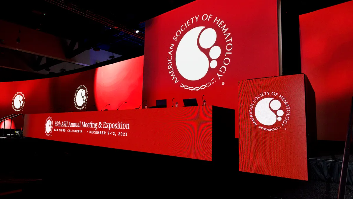 A dias lit up in red with a sign reading 65th ASH Annual Meeting & Exposition