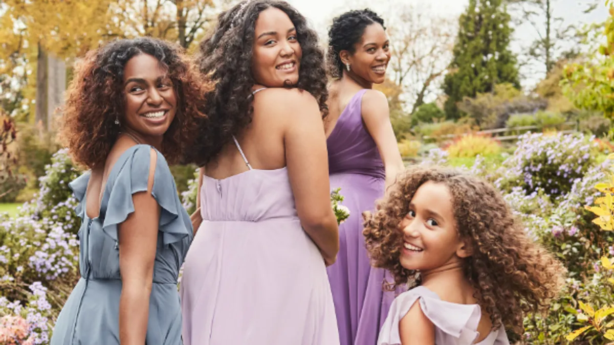 Group of four women wearing bridesmaid dresses.