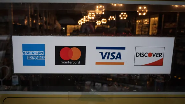 Credit card logos stickers showing on outside of restaurant window.