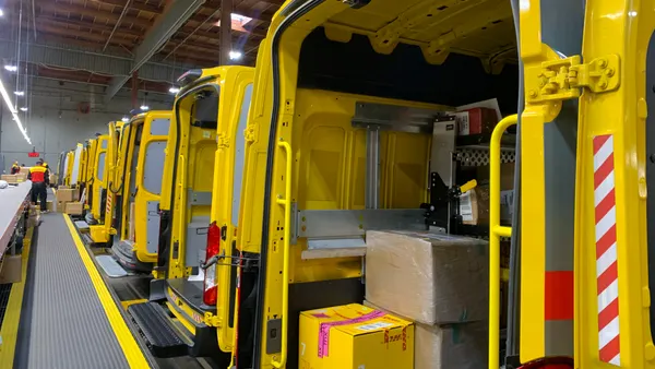 A closeup of the inside of a DHL delivery vehicle with packages stacked inside.