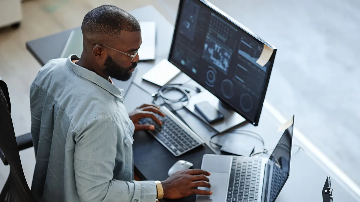 Person working with computers and data systems in office