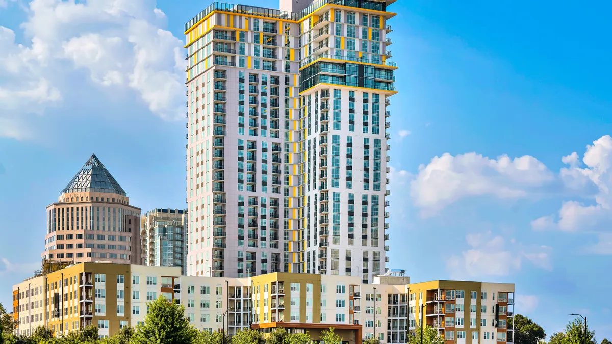 Bright colored high-rise apartments towering above nearby properties.