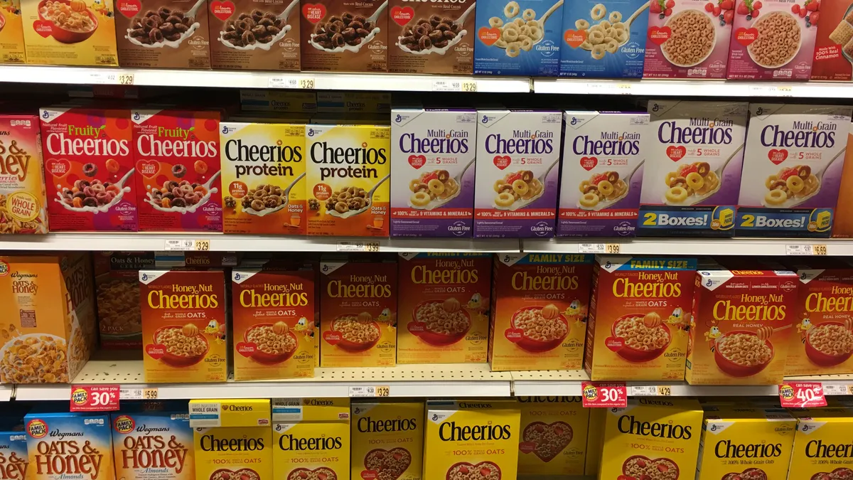 Different varieties of Cheerios on a grocery store shelf.