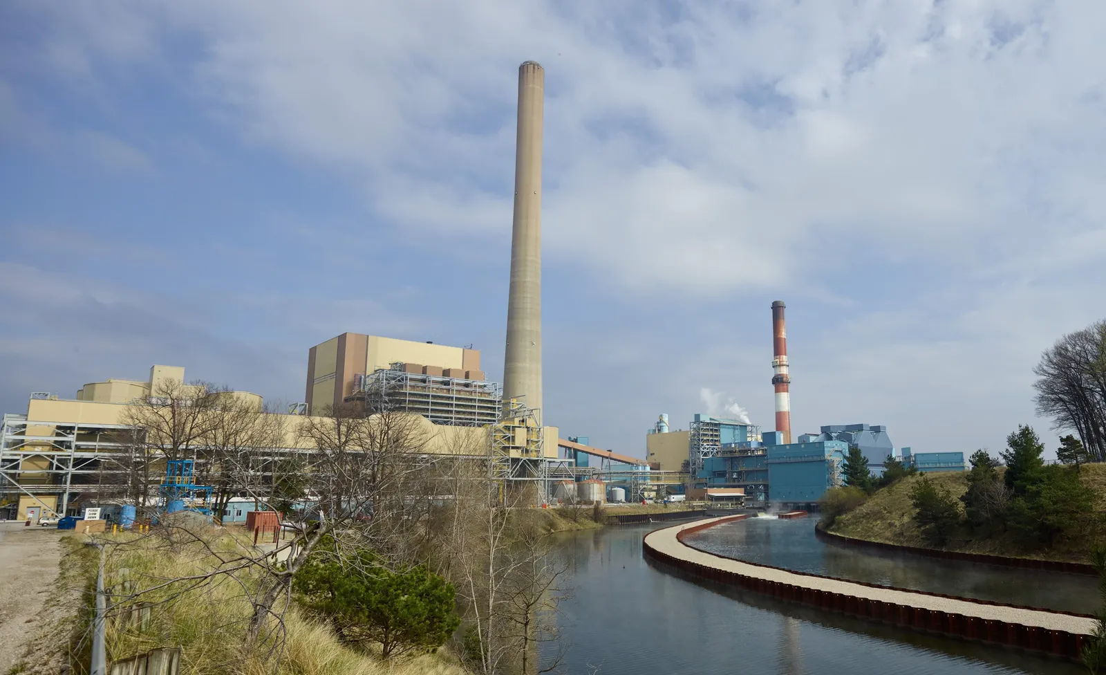 A power plant sites next to a river.