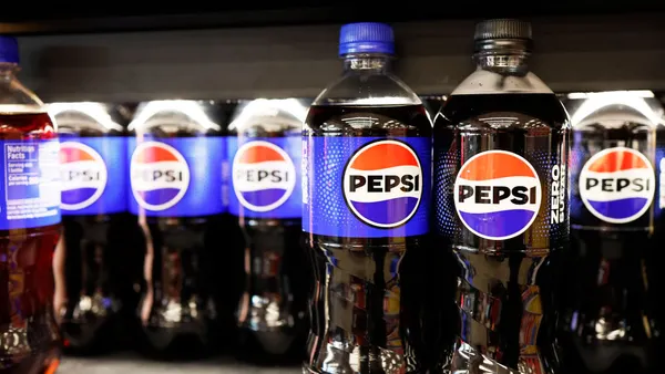 Beverage bottles with Pepsi branding sit on a store shelf.