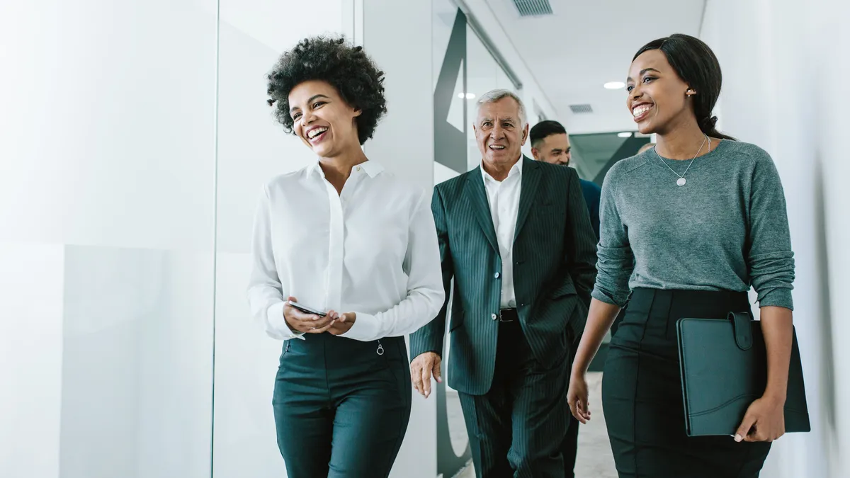 Coworkers walking through an office corridor