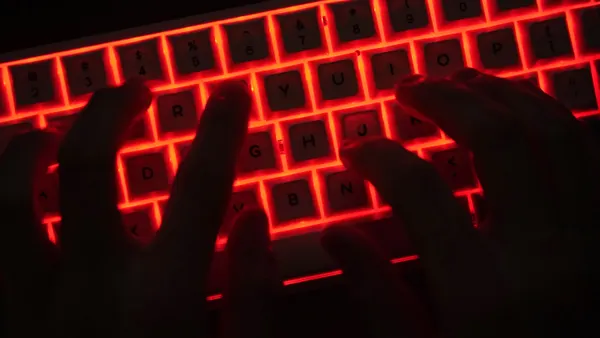 Individual types on a backlit keyboard.