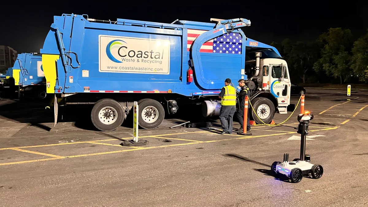 a robot drives by a trash truck