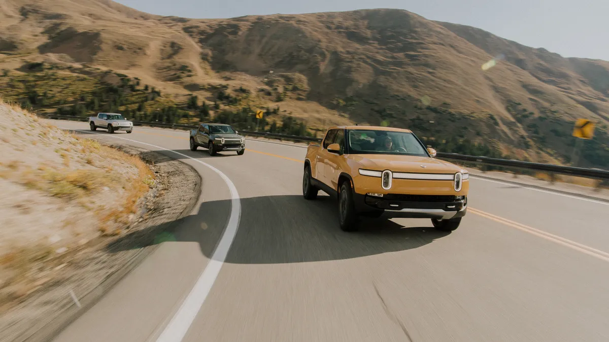 Three 2022 Rivian R1T electric pickups driving.