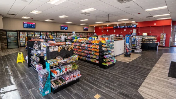 A photo of the interior of a shop, showing rows of merchandise on shelves and in coolers along the walls.