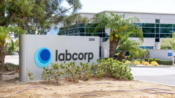 A Labcorp sign in front of an office building and palm trees.
