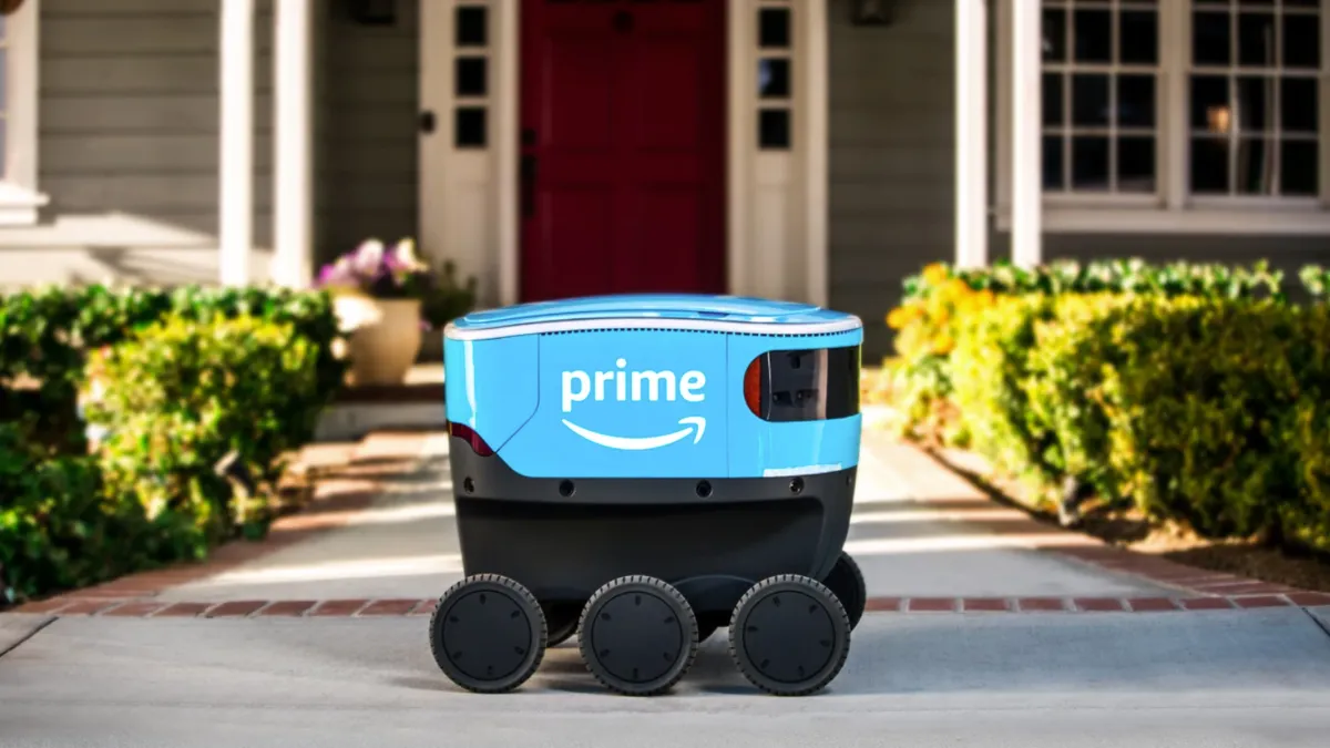 The Amazon Scout delivery robot operates on a sidewalk.