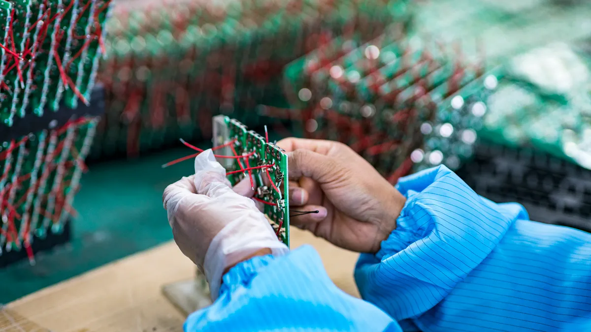 A worker assembles a circuit board.